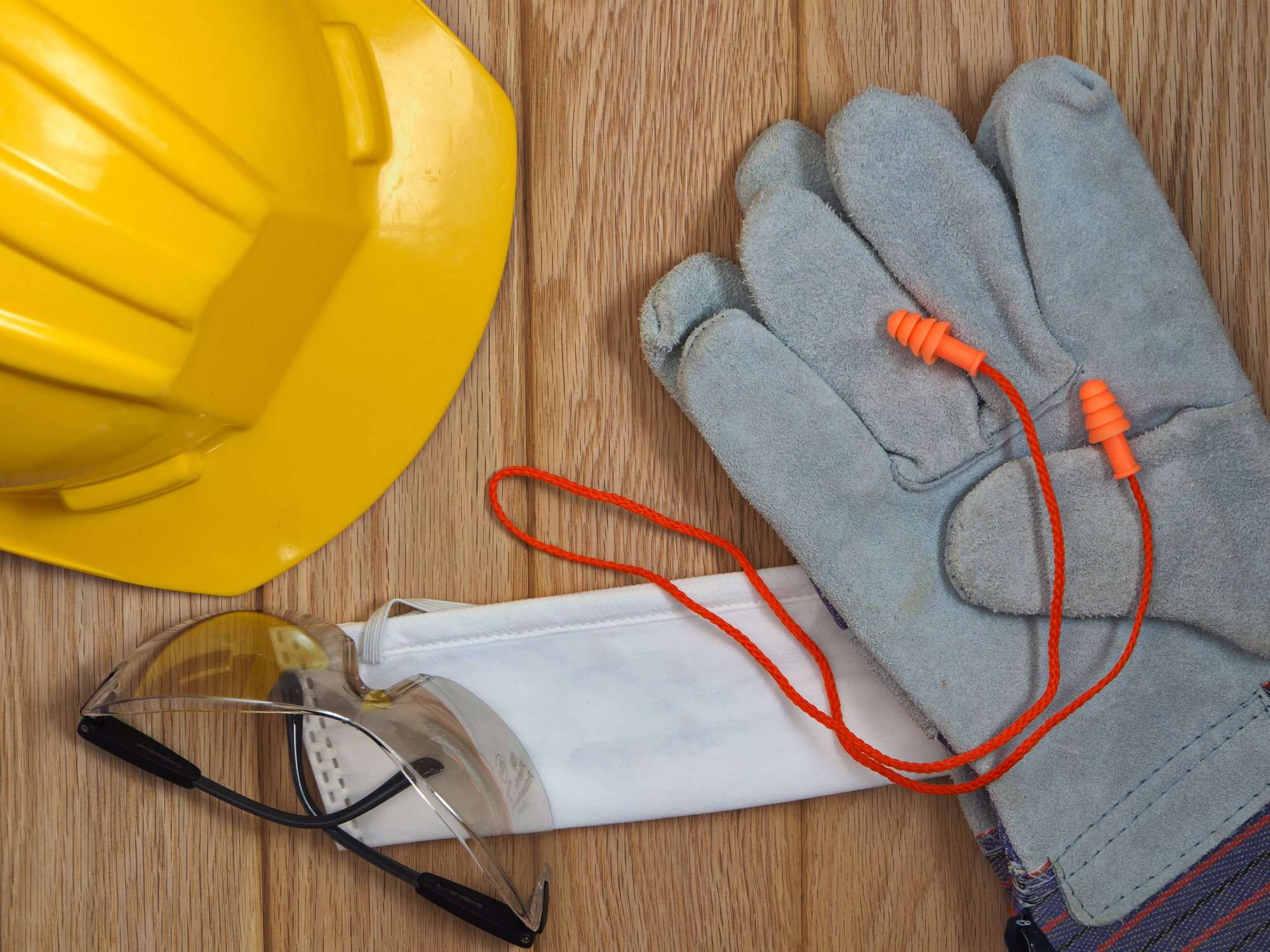 Equipo de protección personal (EPP) industrial: casco de seguridad, lentes de seguridad, tapones auditivos y guantes de trabajo.